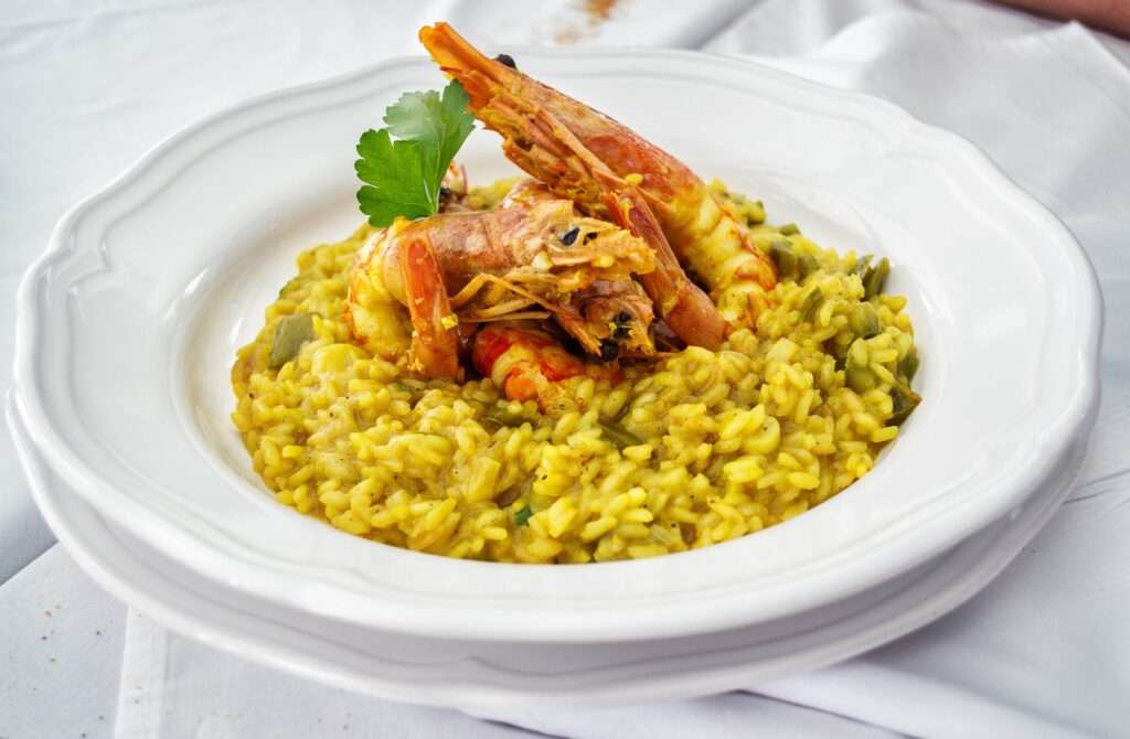 Risotto mit Garnelen auf weißem Teller serviert.