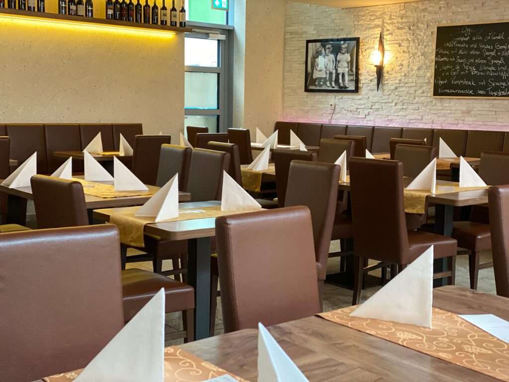 Leeres Restaurant mit gedeckten Tischen und Servietten.