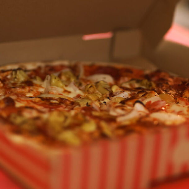 Pizza in offener Schachtel mit Artischocken.